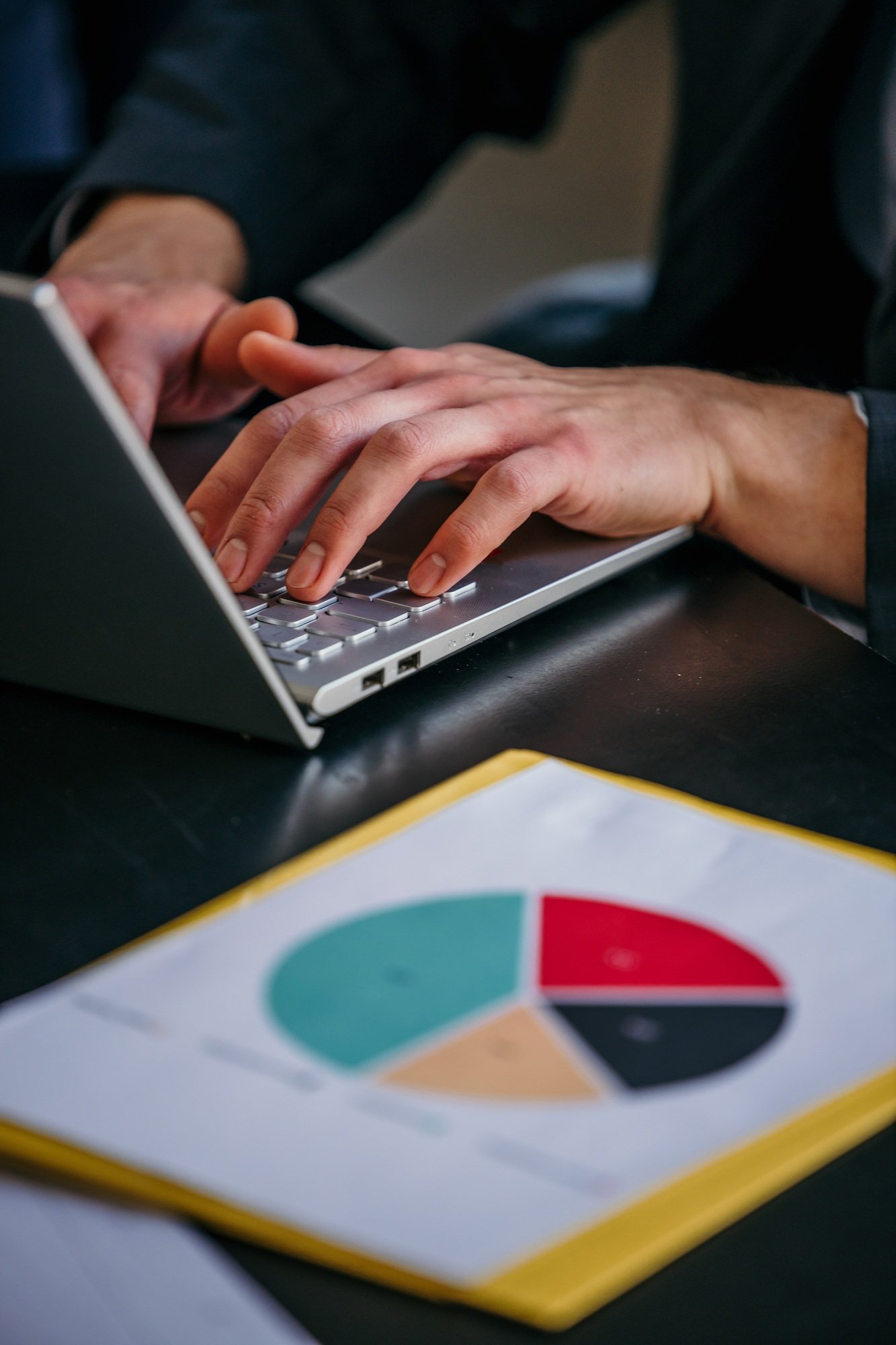 Businessman working on laptop with pie chart report
